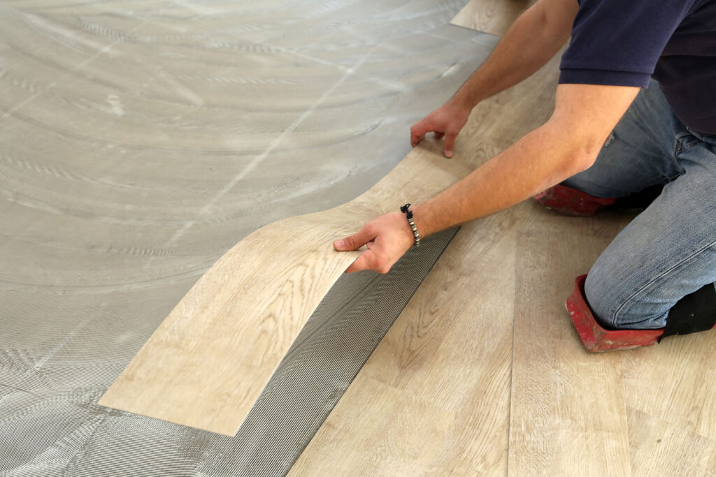 Worker installing new vinyl tile floor | Echo Flooring Gallery